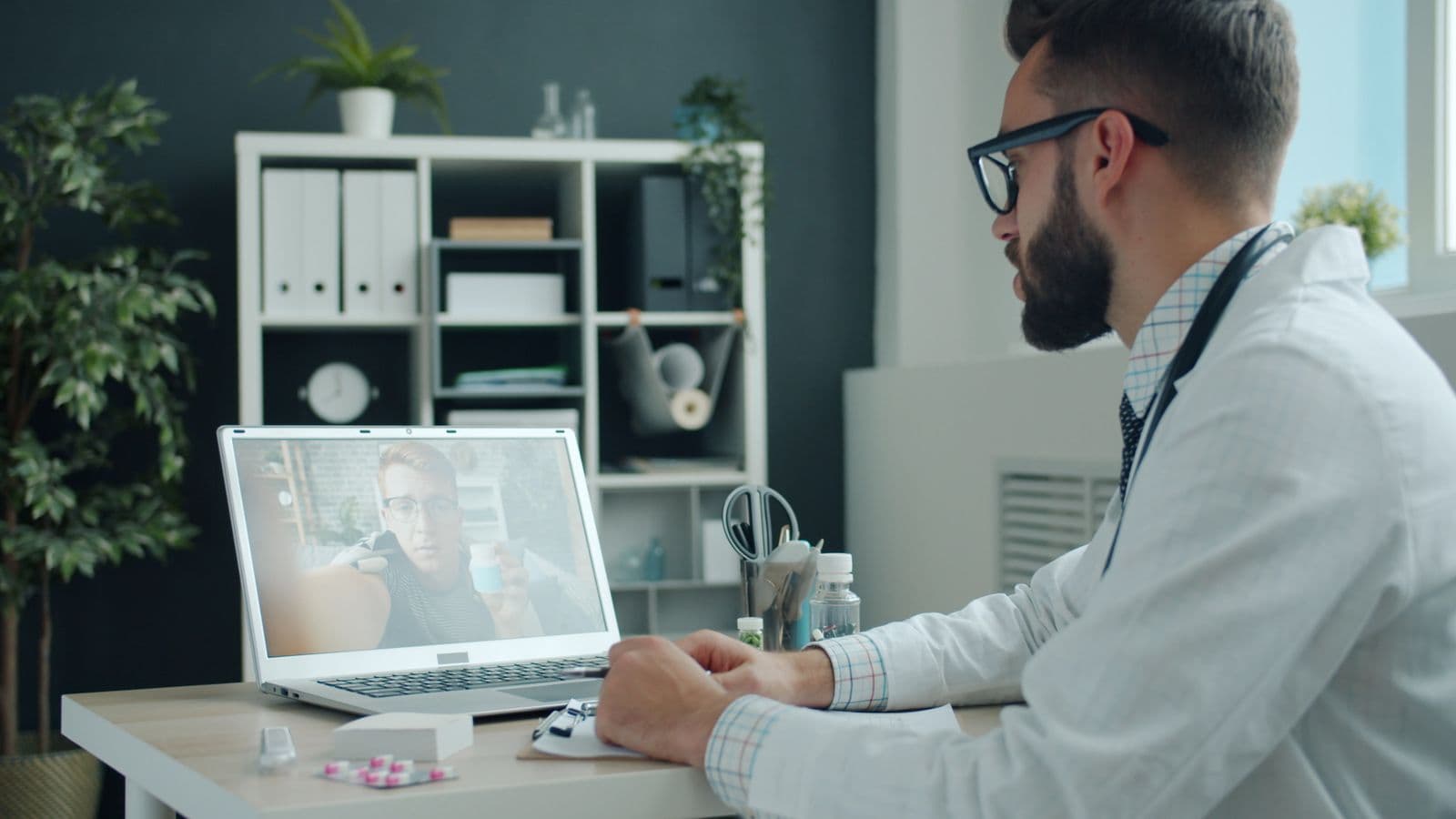 Arzt führt eine Videosprechstunde am Laptop