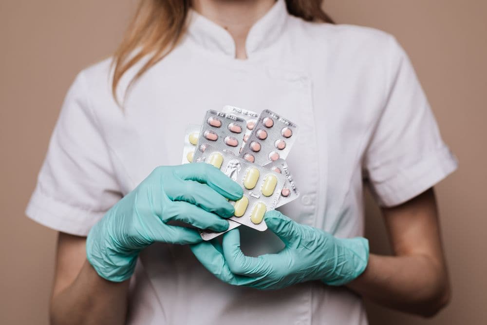 Fachkraft hält Blisterpackungen mit Arzneimitteln